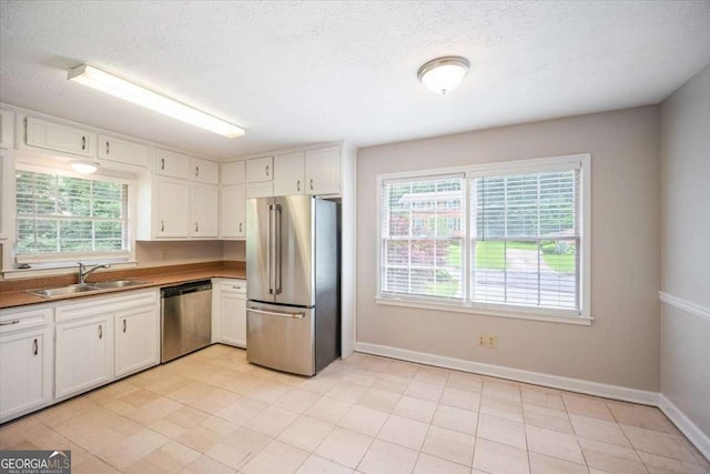3802 Birchbriar Ct, Decatur, GA 30034 - kitchen featuring appliances with stainless steel finishes, a sink, baseboards, white cabinets, and a textured ceiling