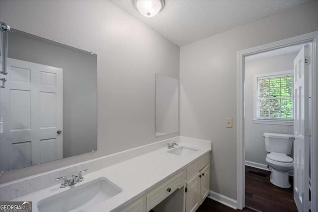 3802 Birchbriar Ct, Decatur, GA 30034 - bathroom with toilet, double vanity, wood finished floors, baseboards, and a textured ceiling