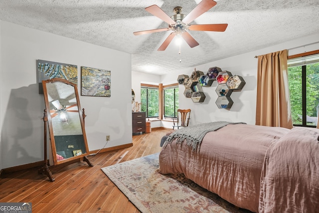 2666 Peachtree Walk, Duluth, GA 30096 - bedroom with a textured ceiling, light wood-type flooring, and a ceiling fan