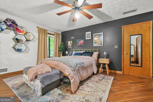 2666 Peachtree Walk, Duluth, GA 30096 - bedroom with a textured ceiling, wood finished floors, and ceiling fan