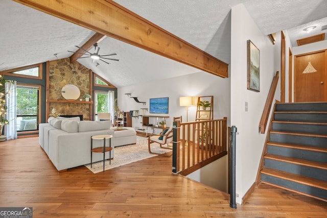 2666 Peachtree Walk, Duluth, GA 30096 - living room featuring healthy amount of natural light, a textured ceiling, wood-type flooring, a stone fireplace, and a ceiling fan