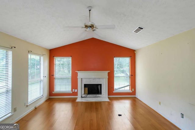9550 Canvasback Ct, Jonesboro, GA 30238 - unfurnished living room featuring a ceiling fan, a premium fireplace, wood finished floors, vaulted ceiling, and a textured ceiling