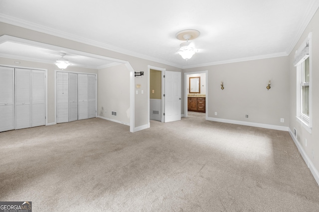 5065 Nesbit Ferry Ln, Atlanta, GA 30350 - unfurnished bedroom featuring multiple closets, ornamental molding, light carpet, and ensuite bathroom