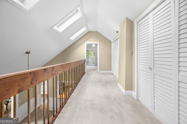 5065 Nesbit Ferry Ln, Atlanta, GA 30350 - hallway featuring a skylight, lofted ceiling, and light colored carpet