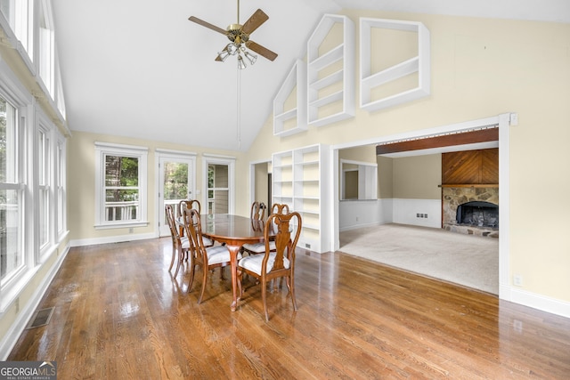 5065 Nesbit Ferry Ln, Atlanta, GA 30350 - dining space with high vaulted ceiling, a ceiling fan, wood finished floors, a tile fireplace, and built in shelves