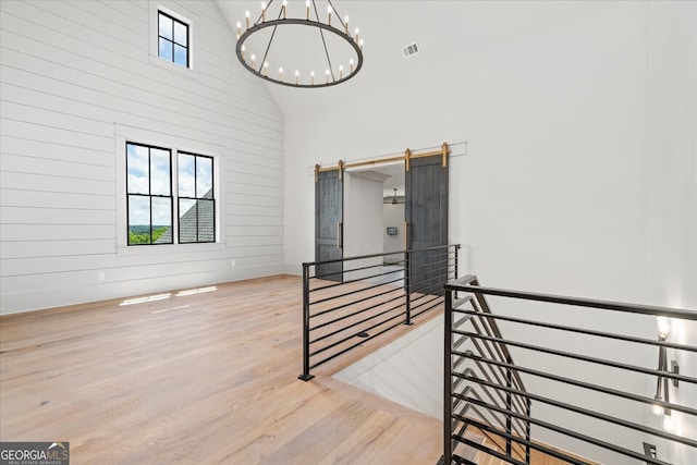 4927 Slaton Dr, Acworth, GA 30101 - staircase with healthy amount of natural light, a towering ceiling, a chandelier, wood finished floors, and a barn door
