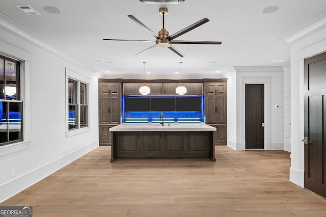 4927 Slaton Dr, Acworth, GA 30101 - kitchen featuring ceiling fan, light countertops, dark brown cabinets, a kitchen island with sink, and crown molding