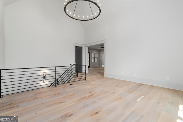 4927 Slaton Dr, Acworth, GA 30101 - unfurnished room with high vaulted ceiling, a chandelier, and wood finished floors