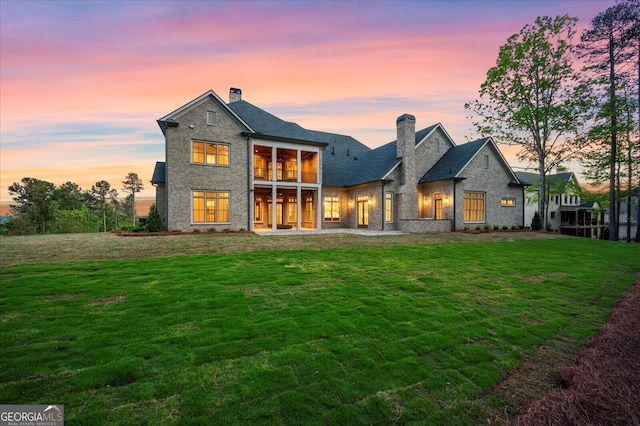 4927 Slaton Dr, Acworth, GA 30101 - back of property at dusk featuring a chimney and a lawn