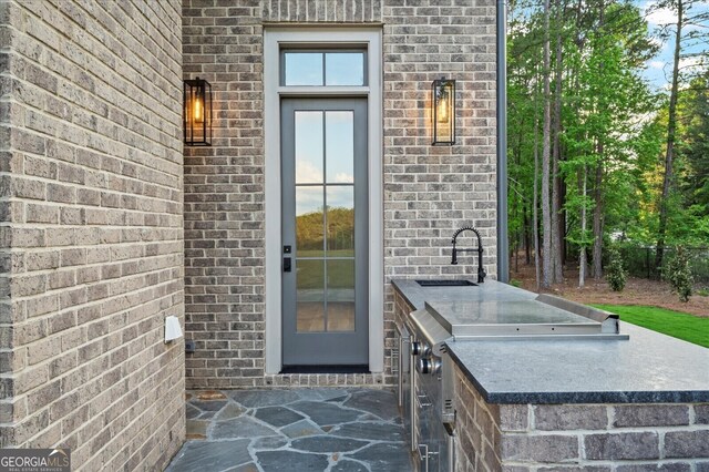 4927 Slaton Dr, Acworth, GA 30101 - view of exterior entry featuring brick siding and area for grilling