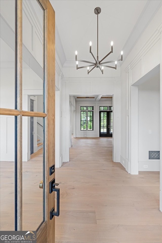 4927 Slaton Dr, Acworth, GA 30101 - hallway with a decorative wall, a chandelier, light wood finished floors, and ornamental molding
