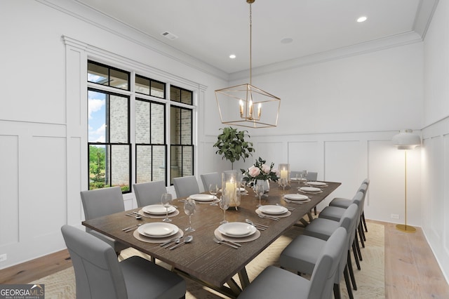 4927 Slaton Dr, Acworth, GA 30101 - dining room with a decorative wall, crown molding, a chandelier, light wood-type flooring, and wainscoting