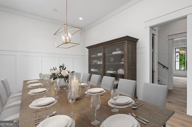 4927 Slaton Dr, Acworth, GA 30101 - dining area featuring a decorative wall, crown molding, light wood-style floors, a chandelier, and a wainscoted wall