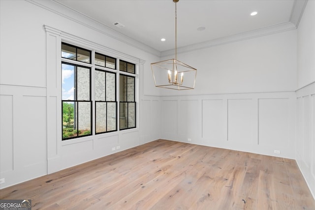 4927 Slaton Dr, Acworth, GA 30101 - unfurnished dining area featuring a decorative wall, plenty of natural light, crown molding, a chandelier, and light wood-type flooring
