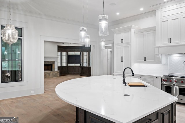 4927 Slaton Dr, Acworth, GA 30101 - kitchen featuring premium range, ornamental molding, light wood-style floors, backsplash, and white cabinets