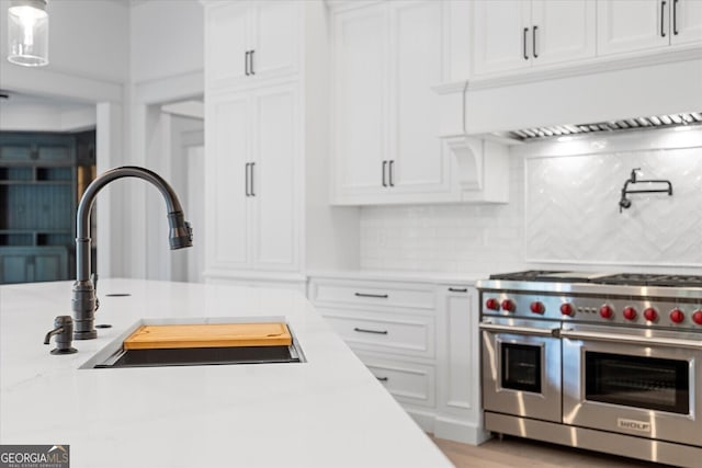 4927 Slaton Dr, Acworth, GA 30101 - kitchen featuring range with two ovens, white cabinets, light countertops, and backsplash