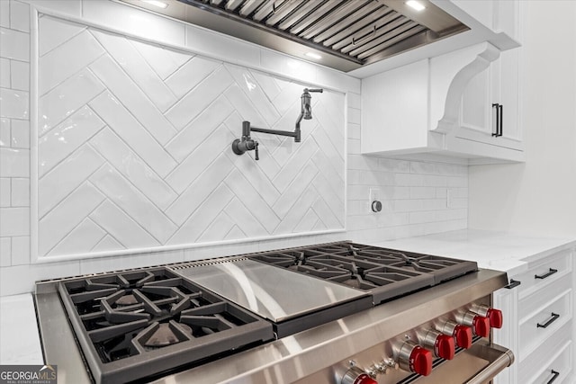 4927 Slaton Dr, Acworth, GA 30101 - kitchen featuring stainless steel stove, decorative backsplash, white cabinets, and light stone counters