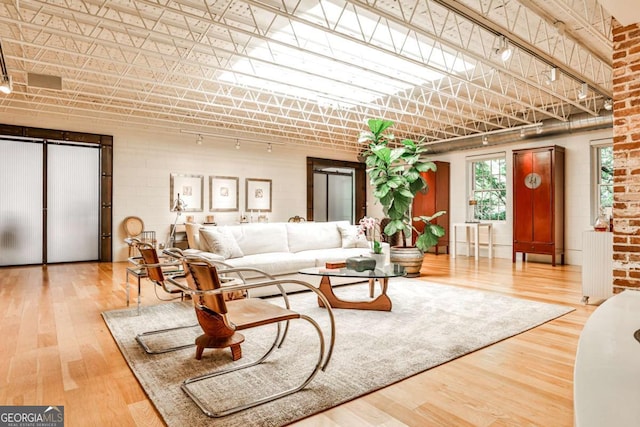 1933 Mclendon Ave NE Unit A, Atlanta, GA 30307 - living room with track lighting, wood finished floors, and brick wall