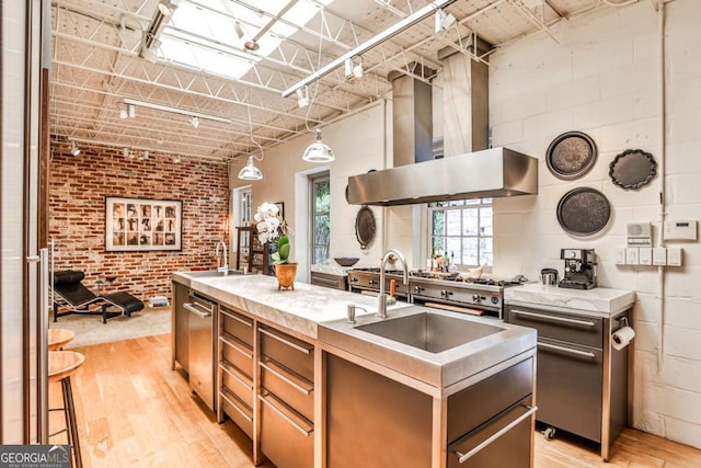 1933 Mclendon Ave NE Unit A, Atlanta, GA 30307 - kitchen with light wood-style floors, range hood, a center island with sink, a sink, and stainless steel dishwasher