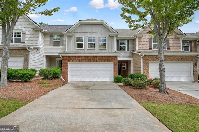 411 Mountain View Ln, Woodstock, GA 30188 - townhome / multi-family property featuring an attached garage, driveway, brick siding, and board and batten siding