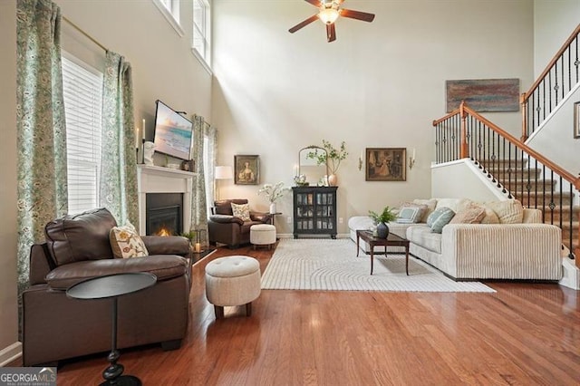 411 Mountain View Ln, Woodstock, GA 30188 - living room with a high ceiling, a ceiling fan, stairway, wood finished floors, and a glass covered fireplace