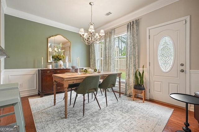 411 Mountain View Ln, Woodstock, GA 30188 - dining area featuring a chandelier, crown molding, wainscoting, wood finished floors, and a decorative wall