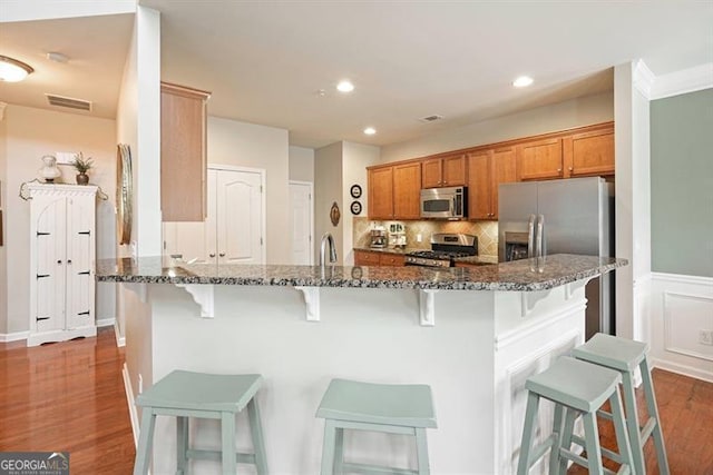 411 Mountain View Ln, Woodstock, GA 30188 - kitchen with stainless steel appliances, dark stone countertops, a kitchen bar, and recessed lighting