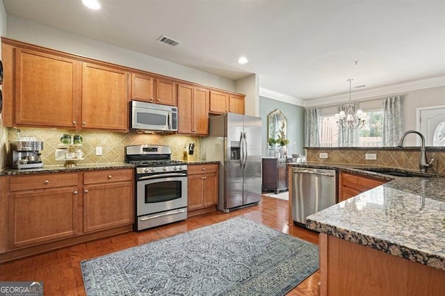 411 Mountain View Ln, Woodstock, GA 30188 - kitchen featuring stainless steel appliances, a sink, a chandelier, decorative backsplash, and brown cabinets