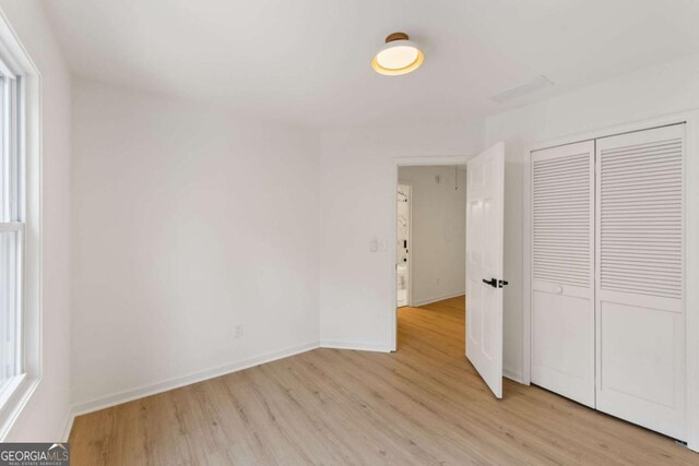 3878 Brookside Pkwy, Decatur, GA 30034 - unfurnished bedroom featuring light wood-type flooring, baseboards, and a closet