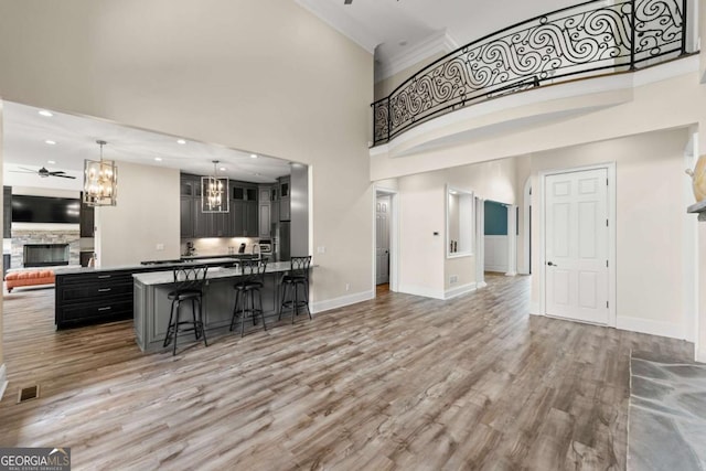 7519 Waterview Cv, Douglasville, GA 30135 - kitchen featuring open floor plan, ceiling fan, a fireplace, a chandelier, and a kitchen breakfast bar