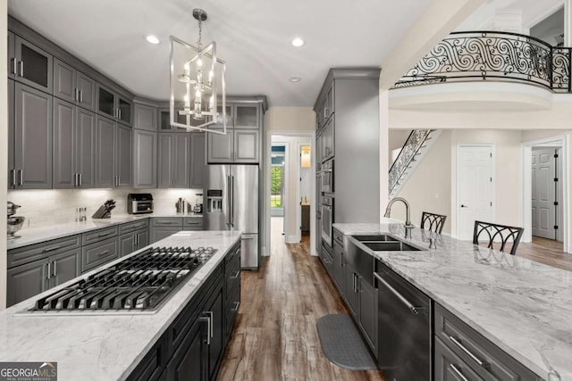 7519 Waterview Cv, Douglasville, GA 30135 - kitchen with appliances with stainless steel finishes, a sink, gray cabinetry, a chandelier, and glass insert cabinets