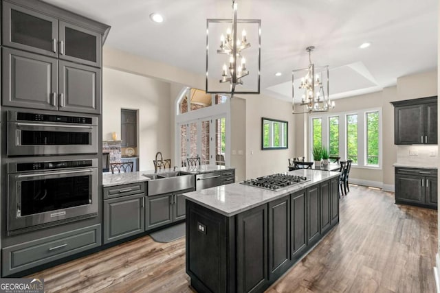 7519 Waterview Cv, Douglasville, GA 30135 - kitchen with stainless steel appliances, a chandelier, a sink, light wood-type flooring, and a center island