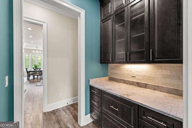 7519 Waterview Cv, Douglasville, GA 30135 - bar featuring baseboards, wood finished floors, decorative backsplash, a chandelier, and recessed lighting