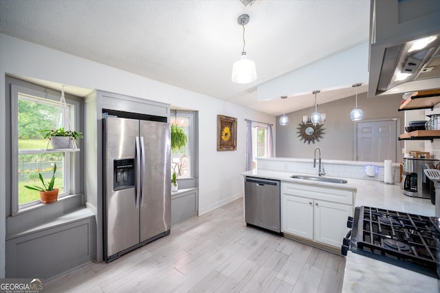 609 Hearth Pl, Lawrenceville, GA 30043 - kitchen featuring appliances with stainless steel finishes, a sink, light countertops, lofted ceiling, and a peninsula