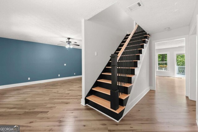 4690 Giddon Martin Rd, Gainesville, GA 30506 - stairway with a textured ceiling, wood finished floors, ceiling fan, and baseboards