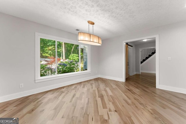 4690 Giddon Martin Rd, Gainesville, GA 30506 - unfurnished room featuring stairs, baseboards, light wood-type flooring, and a textured ceiling