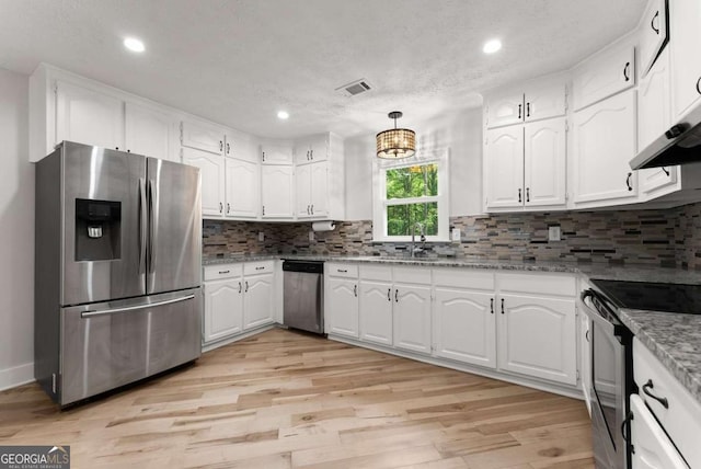 4690 Giddon Martin Rd, Gainesville, GA 30506 - kitchen featuring appliances with stainless steel finishes, light wood-type flooring, white cabinetry, light stone countertops, and decorative backsplash