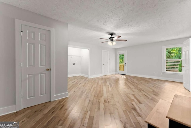 4690 Giddon Martin Rd, Gainesville, GA 30506 - unfurnished living room with ceiling fan, light wood-type flooring, a textured ceiling, and baseboards