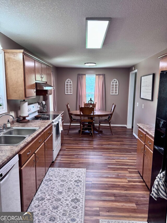 309 Ralph Wommack Rd, Hazlehurst, GA 31539 - kitchen with white appliances, a sink, a textured ceiling, dark wood-type flooring, and baseboards