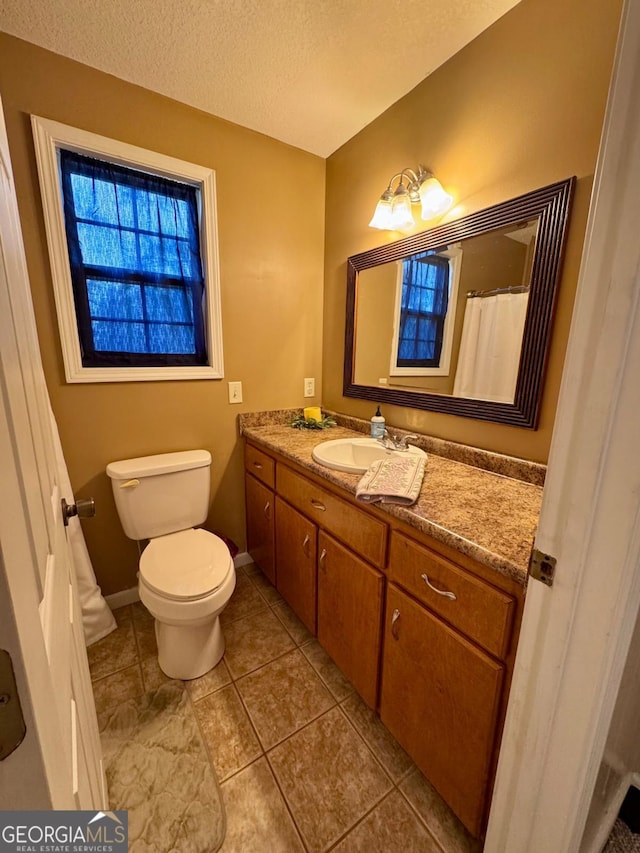 309 Ralph Wommack Rd, Hazlehurst, GA 31539 - bathroom with vanity, toilet, baseboards, tile patterned flooring, and a textured ceiling