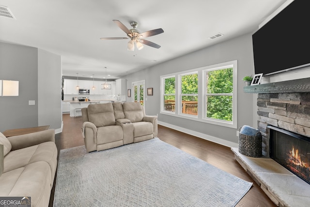 79 Brynbrooke Ct, Dawsonville, GA 30534 - living room with ceiling fan, a stone fireplace, dark wood finished floors, and baseboards