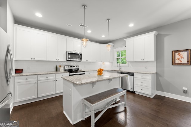 79 Brynbrooke Ct, Dawsonville, GA 30534 - kitchen featuring stainless steel appliances, decorative backsplash, white cabinetry, a center island, and dark wood finished floors