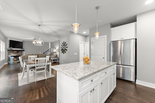 79 Brynbrooke Ct, Dawsonville, GA 30534 - kitchen featuring freestanding refrigerator, dark wood-style floors, a warm lit fireplace, open floor plan, and hanging light fixtures