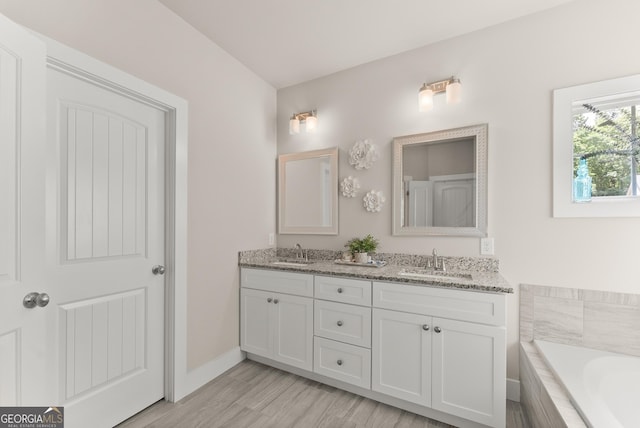 79 Brynbrooke Ct, Dawsonville, GA 30534 - full bath featuring double vanity, a relaxing tiled tub, baseboards, and wood finished floors