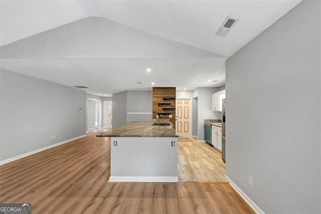 713 Fairfield Dr, Peachtree City, GA 30269 - kitchen with light wood-style flooring, vaulted ceiling, white cabinetry, dark stone countertops, and stainless steel dishwasher