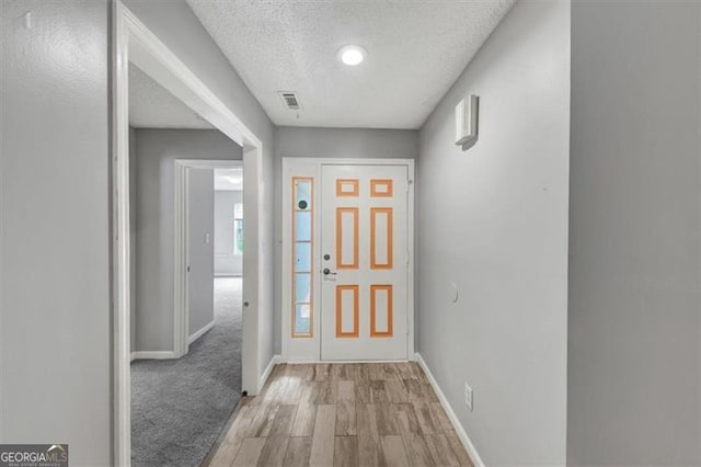 713 Fairfield Dr, Peachtree City, GA 30269 - foyer featuring a textured ceiling, light wood-style floors, and baseboards