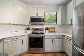 821 Ralph Mcgill Blvd NE Unit 2219, Atlanta, GA 30306 - kitchen with appliances with stainless steel finishes, light countertops, and wood finished floors