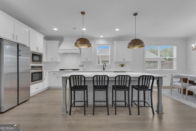155 Lapis Lake Pt, Fayetteville, GA 30215 - kitchen featuring custom exhaust hood, appliances with stainless steel finishes, a kitchen island, healthy amount of natural light, and crown molding