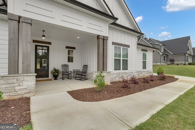 155 Lapis Lake Pt, Fayetteville, GA 30215 - doorway to property featuring board and batten siding, stone siding, a porch, and a lawn