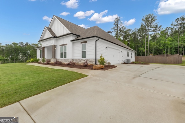 155 Lapis Lake Pt, Fayetteville, GA 30215 - view of side of home with board and batten siding, a shingled roof, concrete driveway, central AC, and stone siding